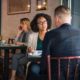 Two people speaking to each other in a coffee shop.