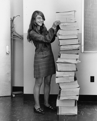 Margaret Hamilton next to the pages of code